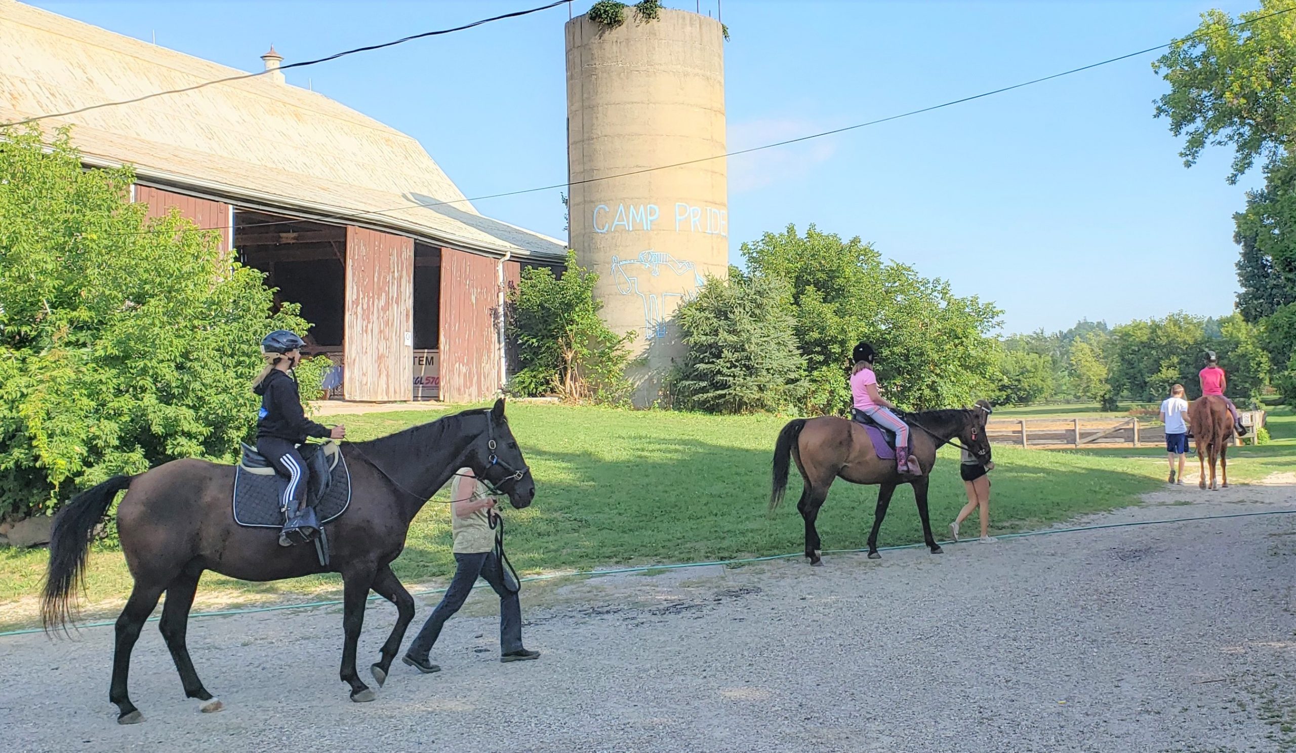 campers on horses by the silo